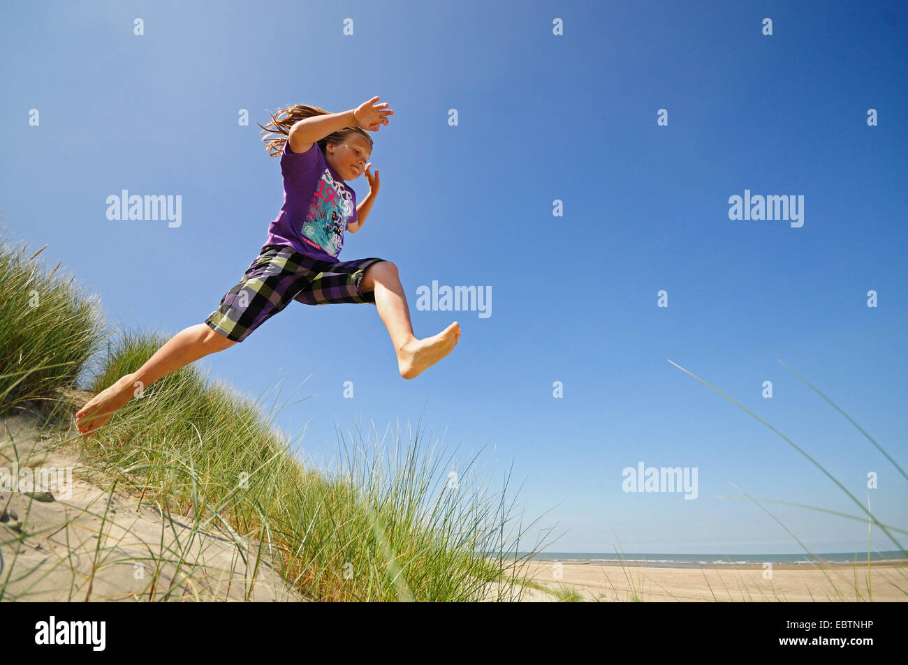energische junge springen aus den Dünen, Niederlande Stockfoto