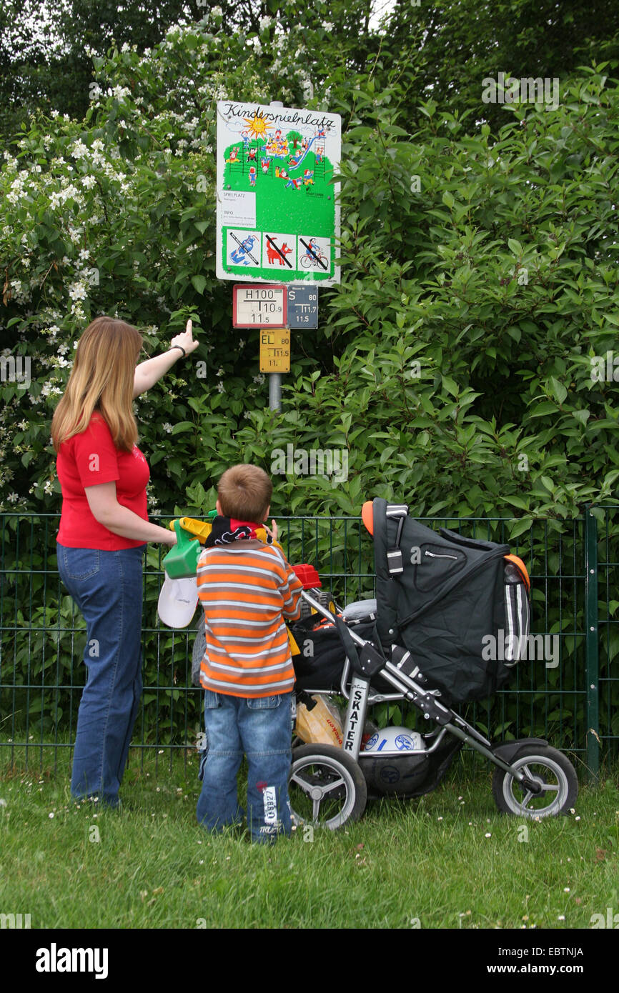 Mutter erklären, ein Hinweisschild am Spielplatz zu ihrem Sohn, Deutschland, Nordrhein-Westfalen Stockfoto