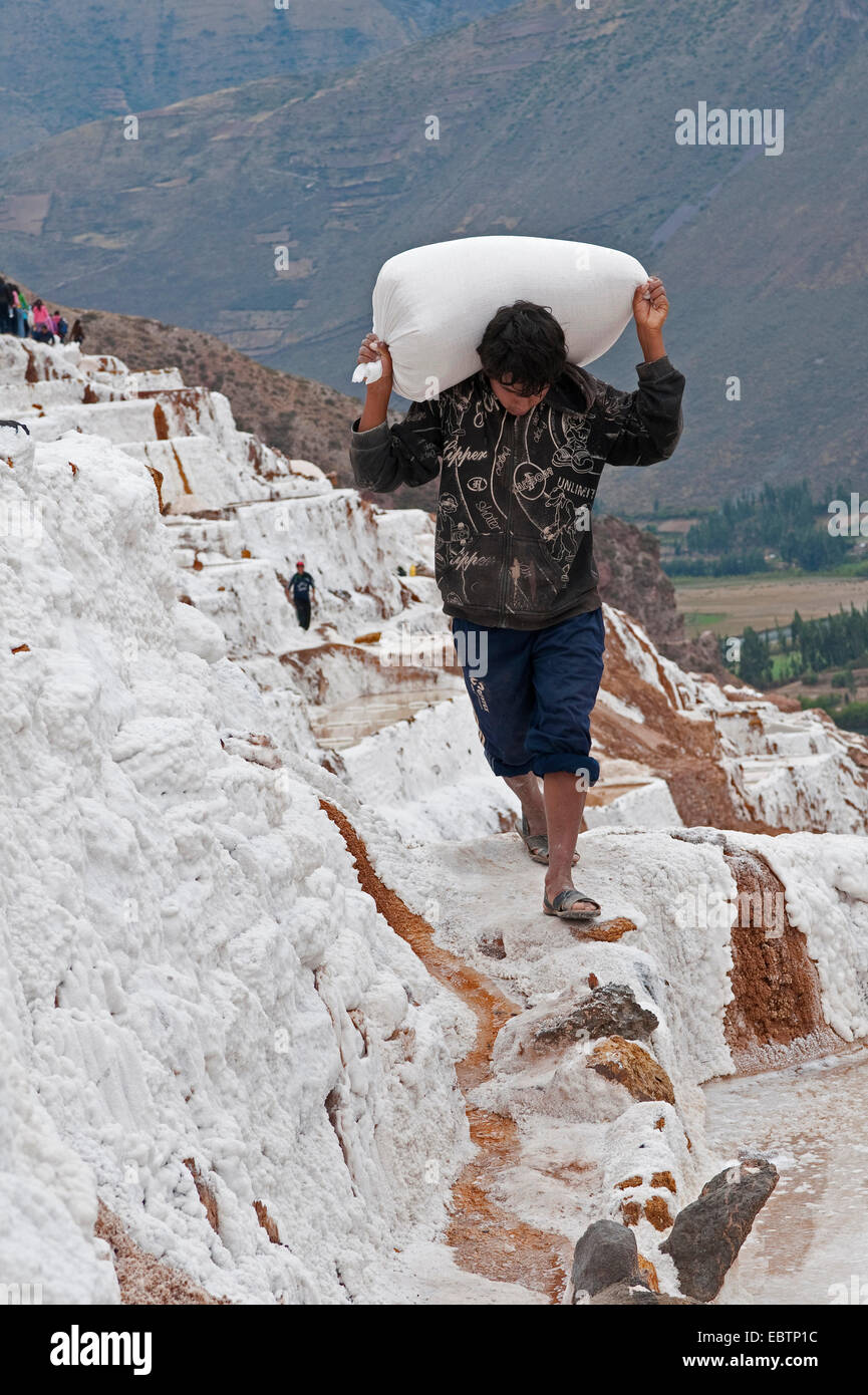 Arbeiter schleppen Salz bei Salt Pfannen Salinas De Maras, Peru, Maras Stockfoto