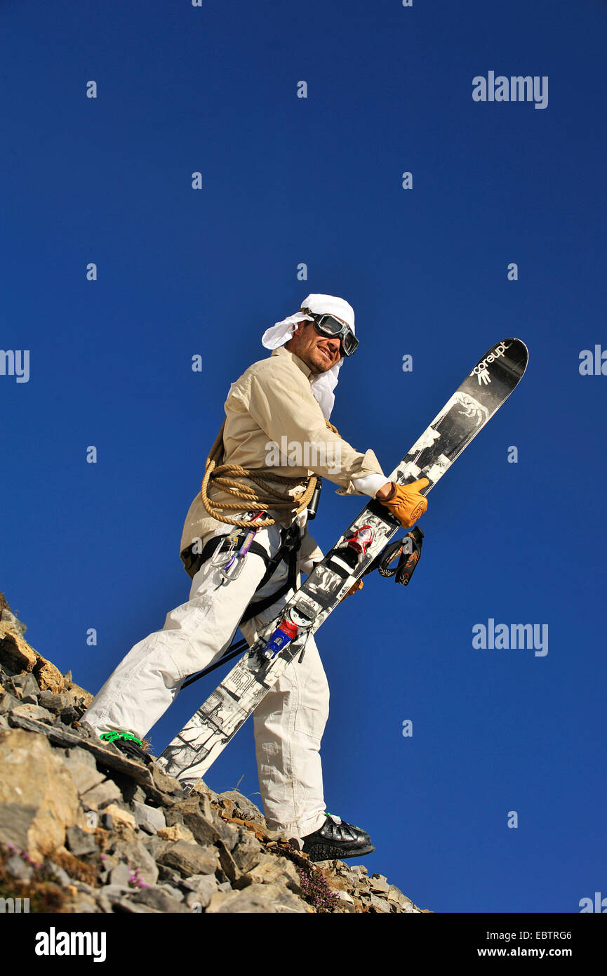 Freeride-Skifahrer getarnt als altmodisch Abenteurer auf felsigen Hang stehend Stockfoto