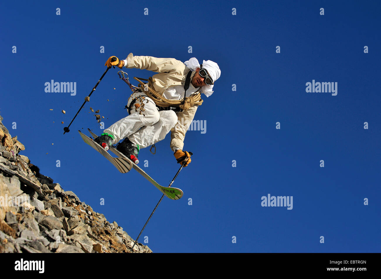 Freeride-Skifahrer getarnt als altmodisch Abenteurer auf felsigen Hang bergab Stockfoto
