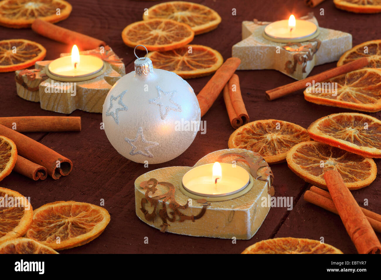 Weihnachts-Dekoration mit Zimtstangen, Orangen Scheiben und Kerzen Stockfoto