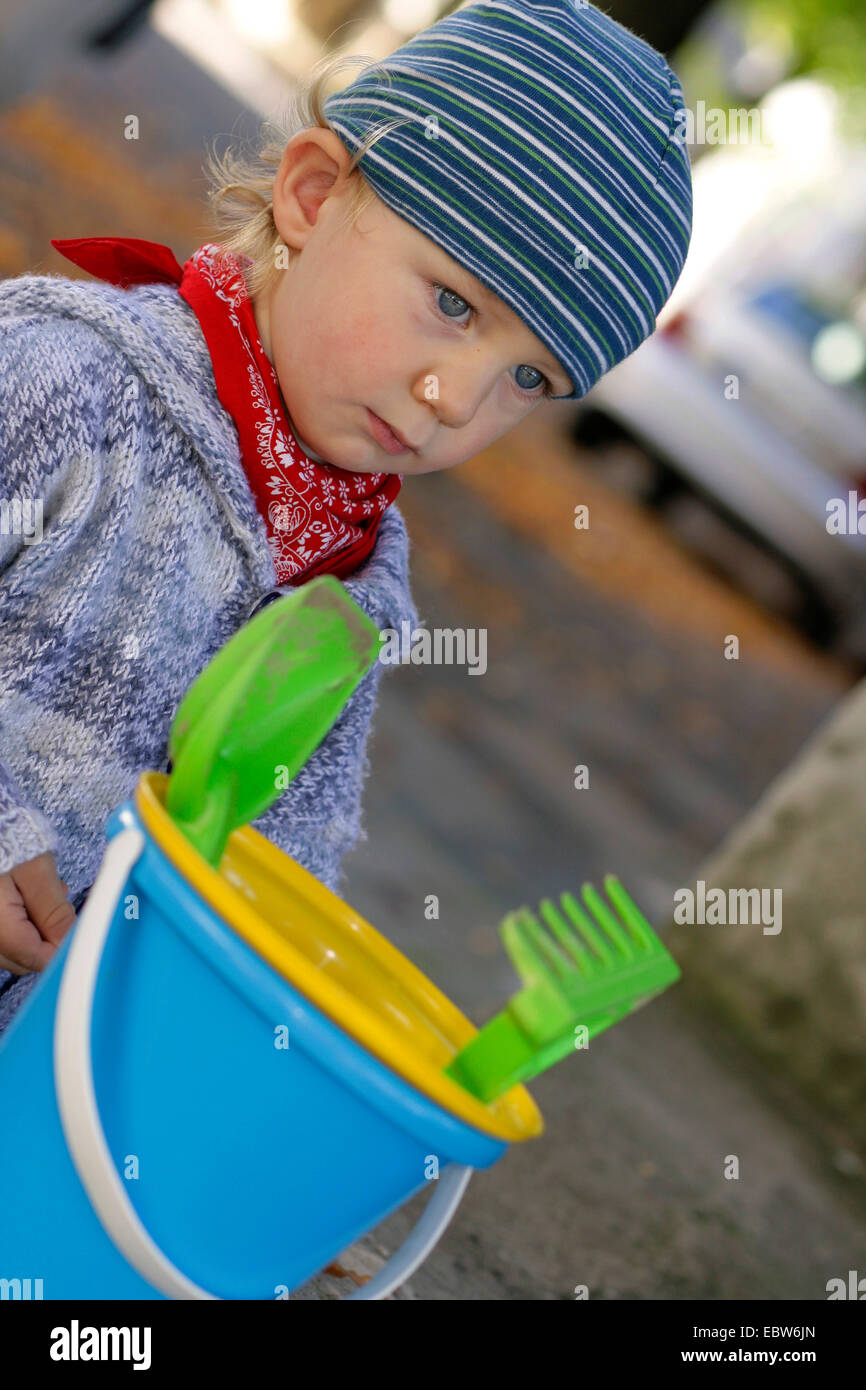 kleiner Junge mit Sandspielzeug auf dem Weg zum Spielplatz Stockfoto