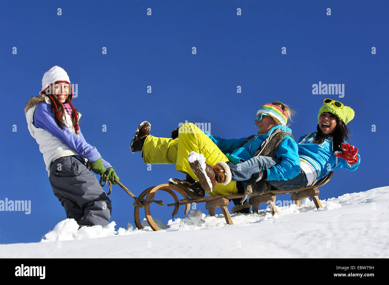 drei junge Mädchen im Schnee Spaß mit einem Schlitten, Frankreich Stockfoto