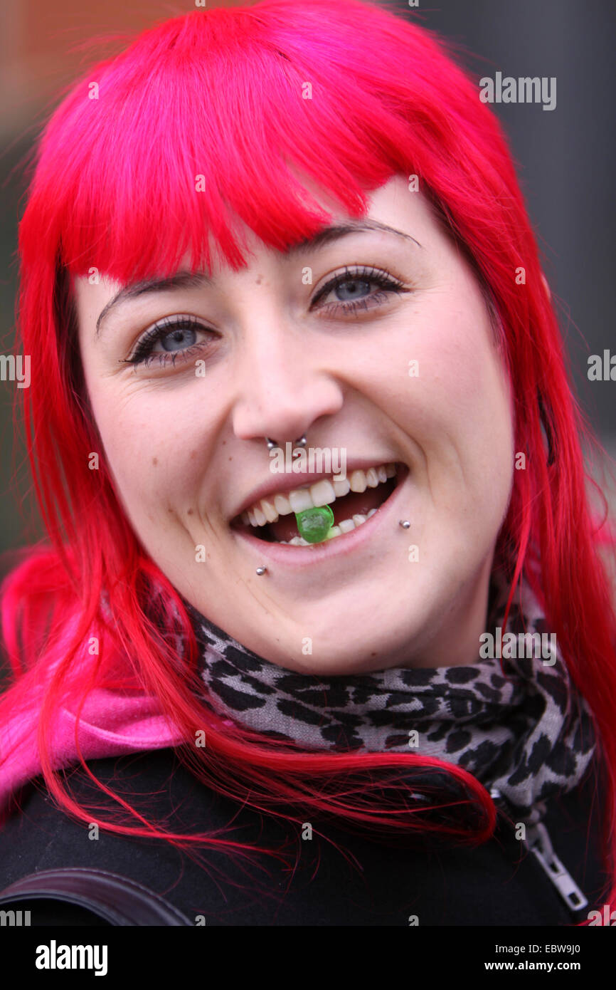 junge Frau mit rosa Haaren Süßigkeiten essen Stockfoto