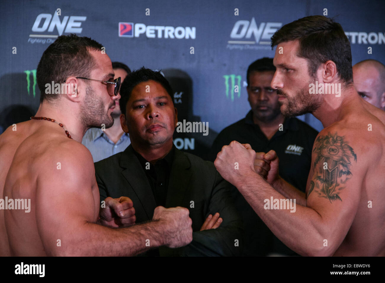 Sylvain Potard (L) von Frankreich und Jake Butler (R) der U.S.A. Face off während der OneFC-wiegen am Mall von Asien Atrium als OneFC CEO Victor Cui blickt auf. Ein Fighting Championship CEO Victor Cui führen die offiziellen Wiegen ein FC: Weg des Kriegers im Atrium Mall of Asia in Pasay City. Hauptereignis ist zwischen einem FC Bantamgewicht Weltmeister, Bibiano Fernandes und Dae Hwan Kim aus Korea. © J Gerard Seguia/Pacific Press/Alamy Live-Nachrichten Stockfoto