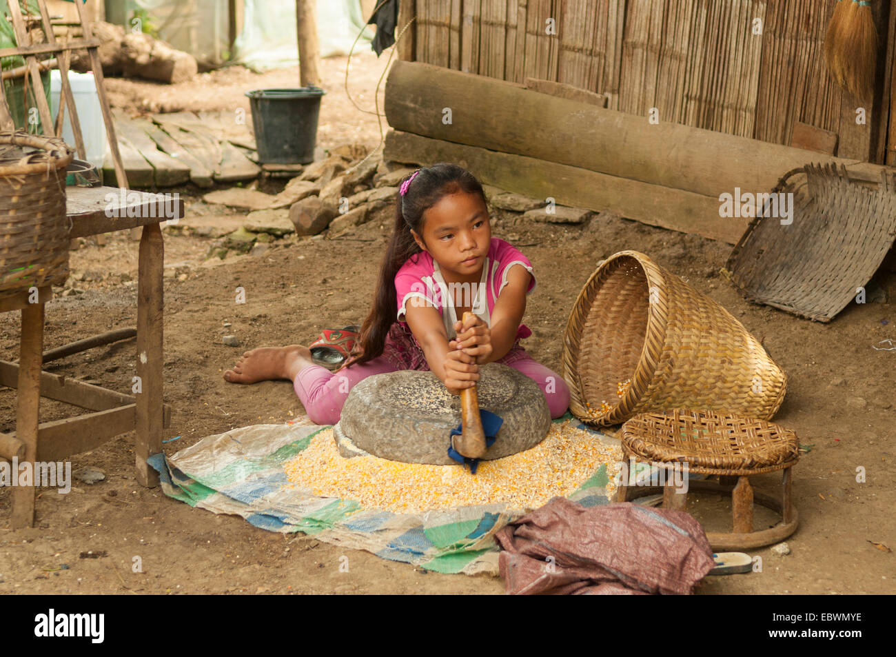 Hmong Kind Mahlen von Mais in Ban Na Ouane, Laos Stockfoto
