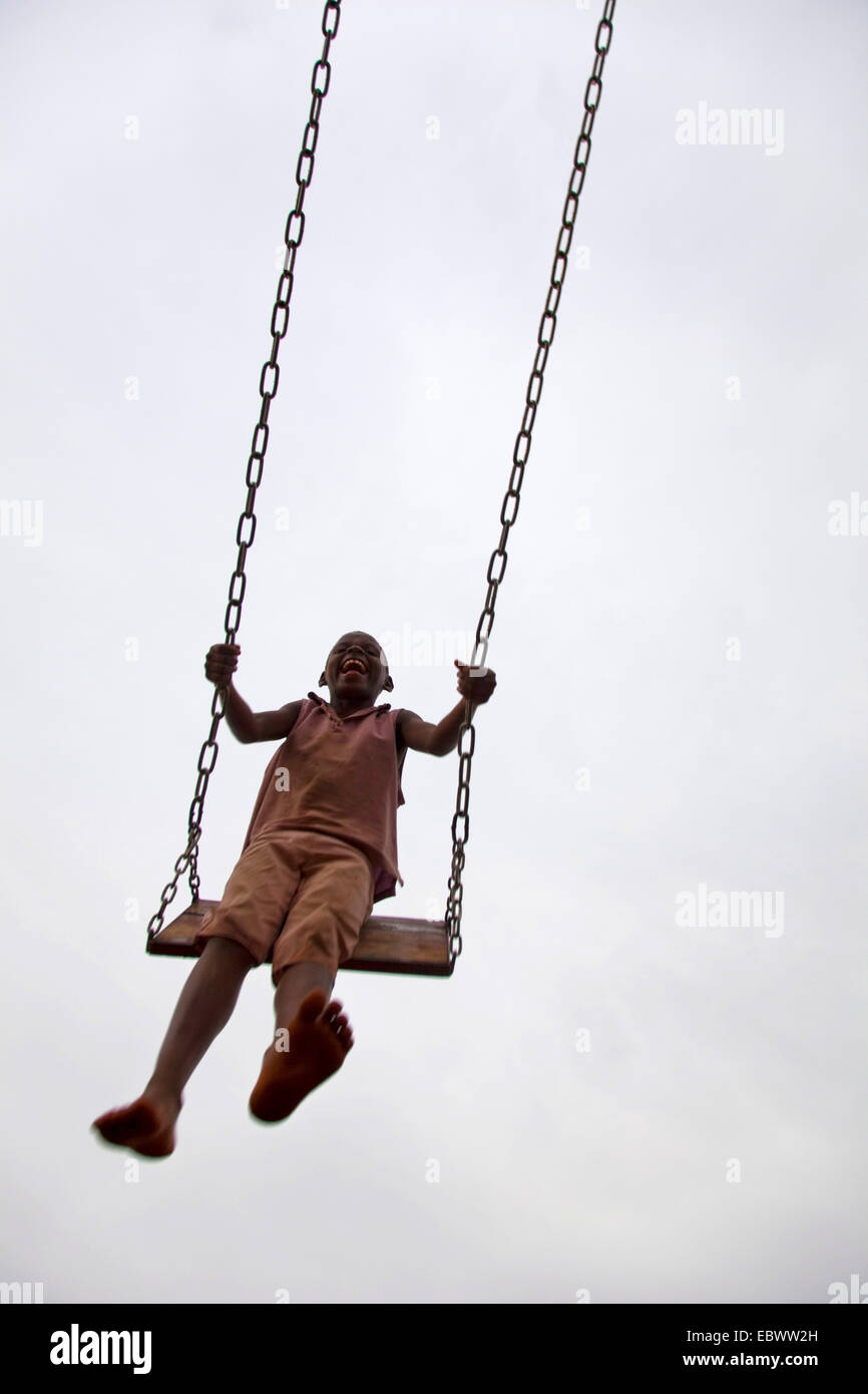 kleines Mädchen schwingen sich in die Luft, Burundi, Bujumbura Stockfoto