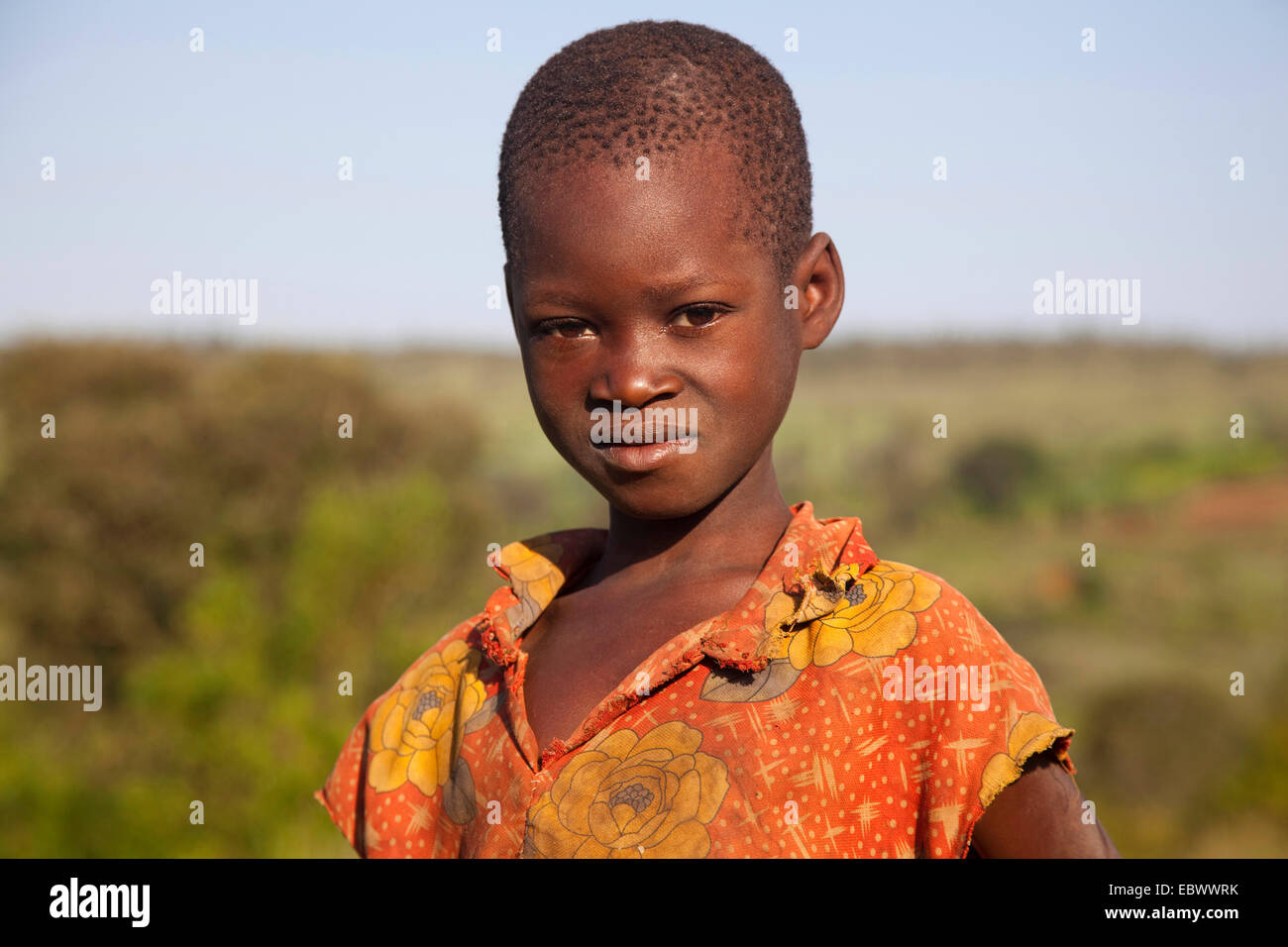 Porträt eines Mädchens vor Buschlandschaft, Burundi, in der Nähe von National Parc De La Ruvubu, Cankuzo Stockfoto