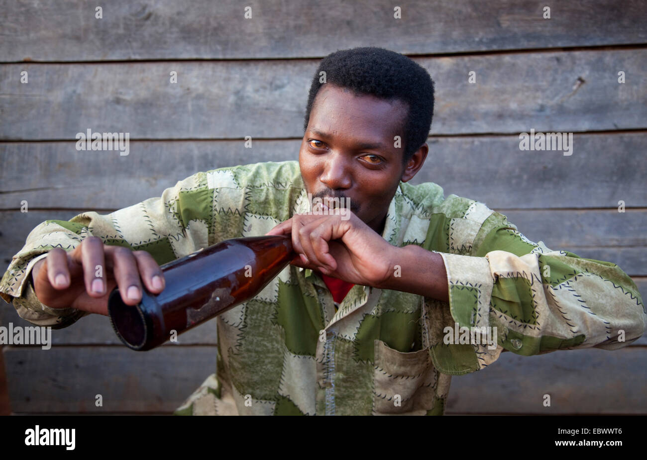 betrunkener Mann Dringing traditionelles Bier mit einem Trink-Stroh, Burundi, in der Nähe von National Parc De La Ruvubu, Cankuzo Stockfoto