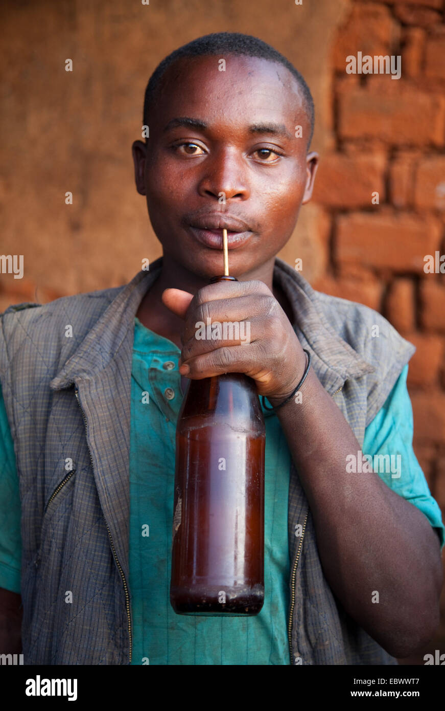junger Mann Dringing traditionelles Bier mit einem Trink-Stroh, Burundi, Cankuzo, in der Nähe von National Parc De La Ruvubu, Cankuzo Stockfoto