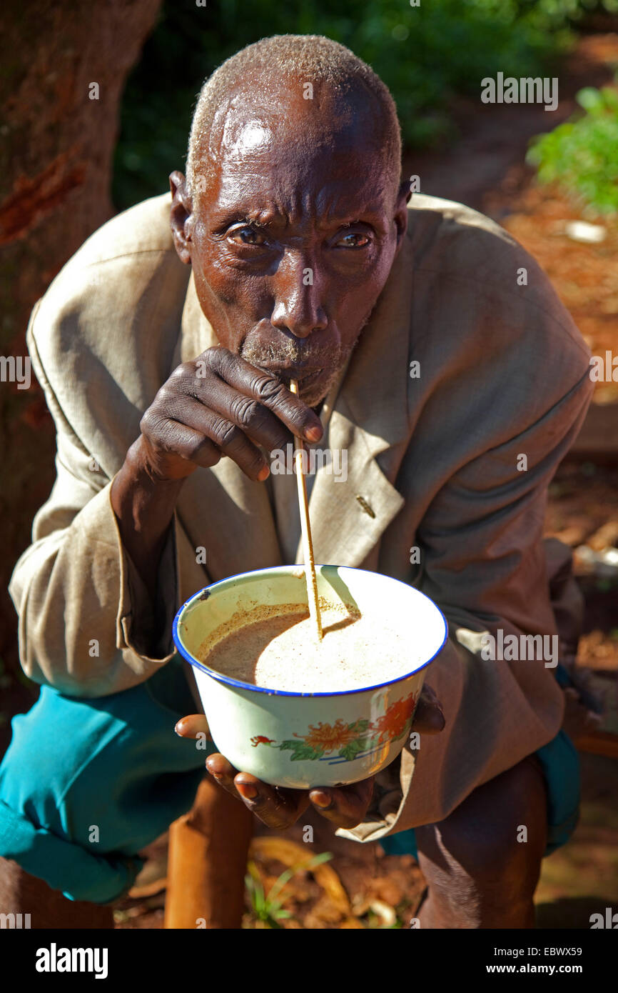 Mann, die traditionellen Bananen Bier 'Pombe"mit dem Trinken Stroh, Burundi, Cankuzo, Cankuzo Stockfoto