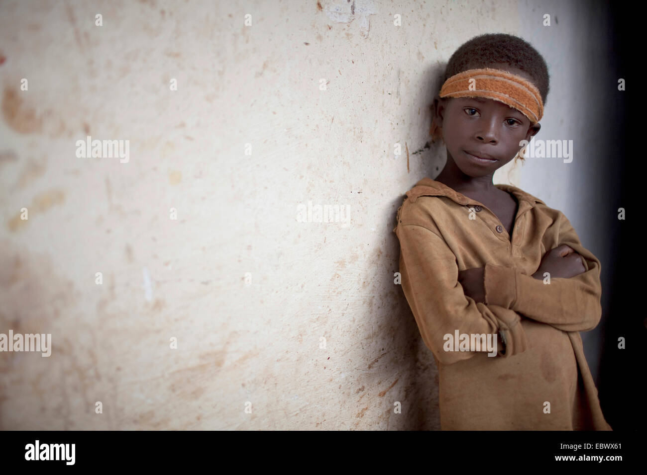 Porträt eines jungen Mannes, der an einer Hauswand in einem Fischerdorf, Burundi, Nyanza Lac, Mvugo, Nyanza Lac gelehnt Stockfoto