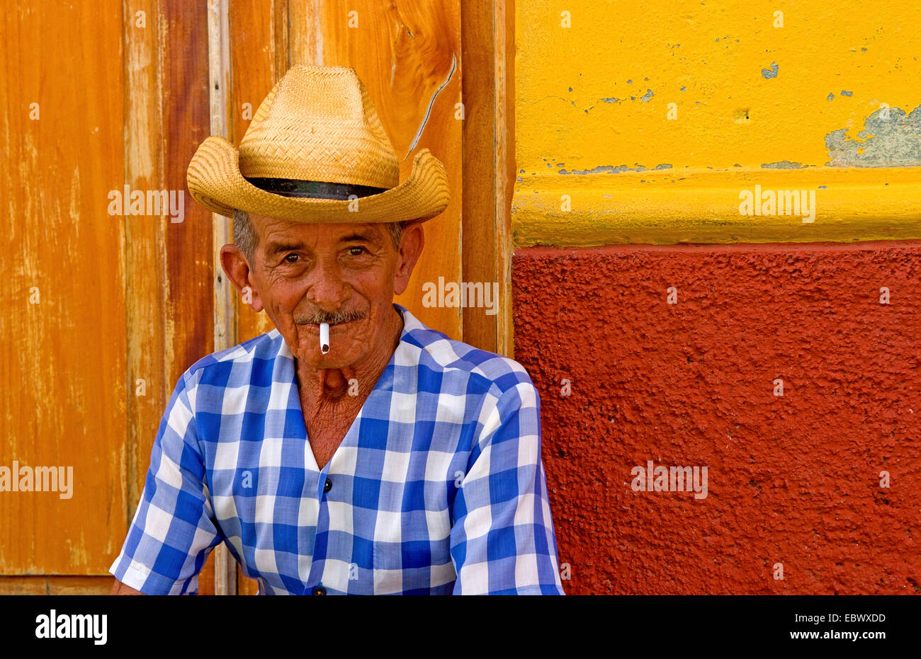 Alter Cowboy mit Hut vor gelbe Wand in Kuba, Porträt, Kuba, Trinidad Stockfoto