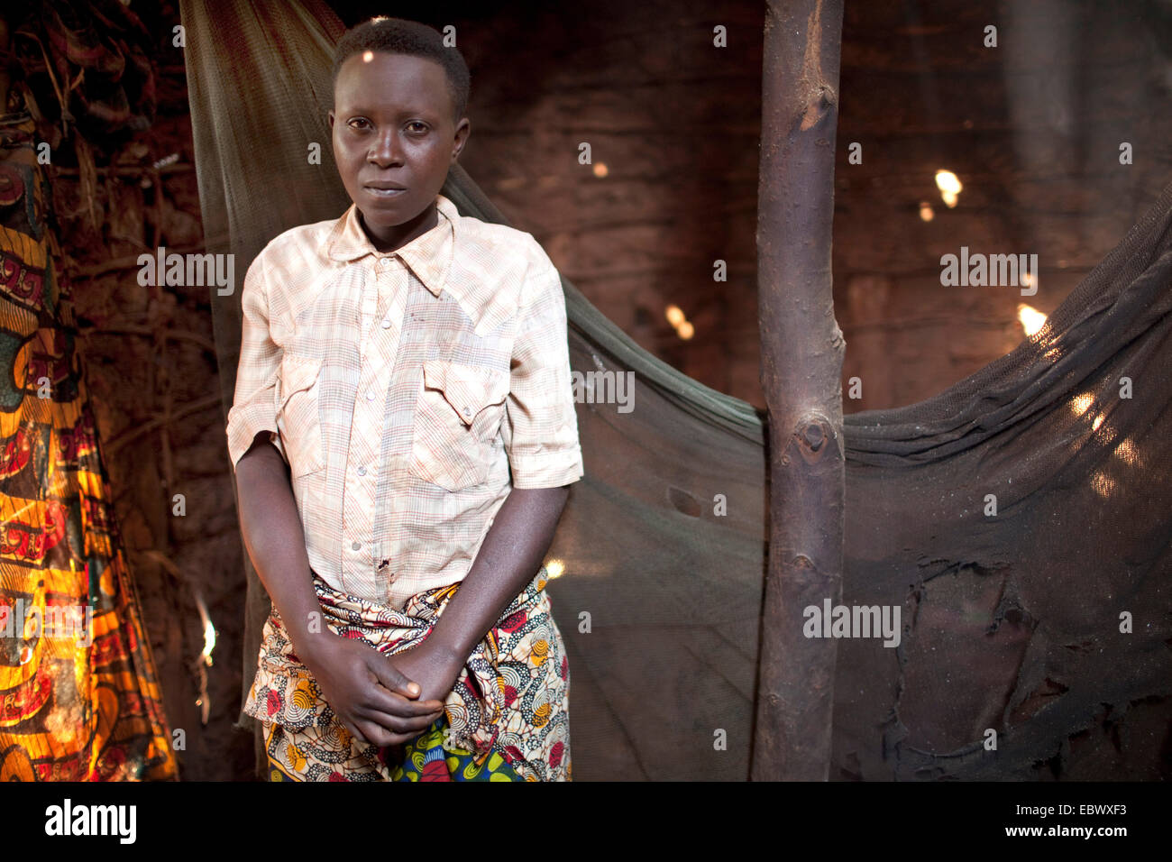 alleinerziehende Mutter mit vier Kindern vor beschädigten Moskitonetz in ihr kleines Lehmhaus, Burundi, Karuzi, Buhiga Stockfoto
