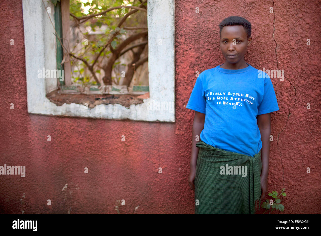 junge Frau trägt ein T-shirt mit der Aufschrift "ich wirklich mehr in Haus drauf steht man vor einem Haus Aufmerksamkeit haben sollte" zerstört im Krieg, Burundi, Karuzi, Buhiga Stockfoto