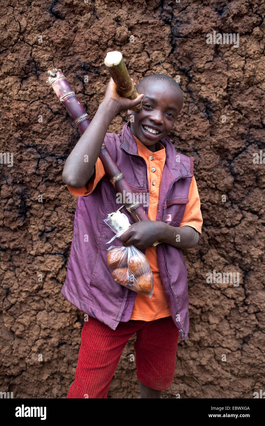 Porträt eines jungen mit Zuckerrohr und eine Tasche mit Backwaren, Burundi, Karuzi, Buhiga Stockfoto