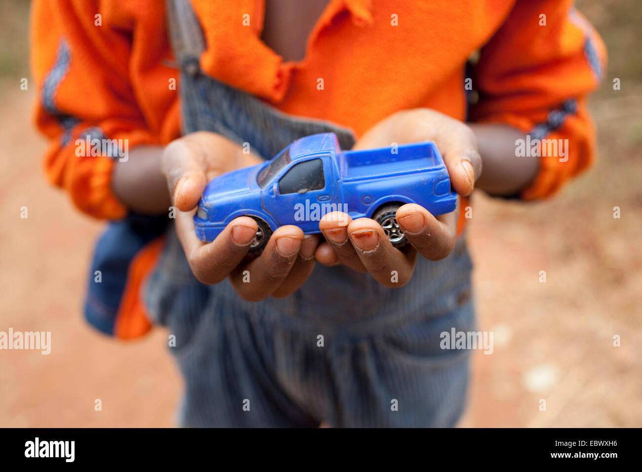 Junge mit einem blauen Spielzeugauto in den Händen, Burundi, Karuzi, Buhiga Stockfoto