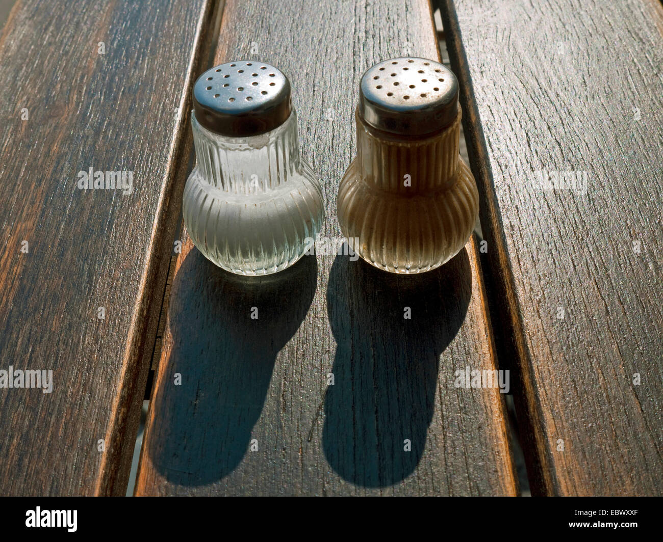 Salz- und Pfefferstreuer auf einem Holztisch Garten Stockfoto