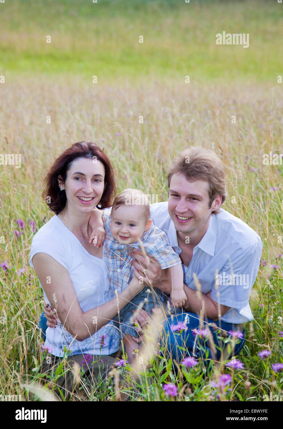 Eltern mit ihren 9 Monate alten Sohn auf einer Wiese Stockfoto