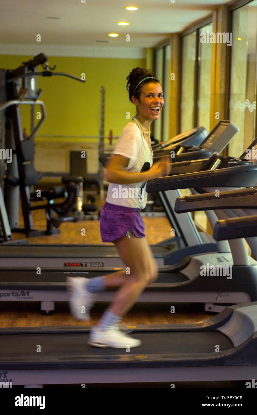 junges Mädchen in ein Fitness-Center lachen während Runing auf einem Laufband Stockfoto