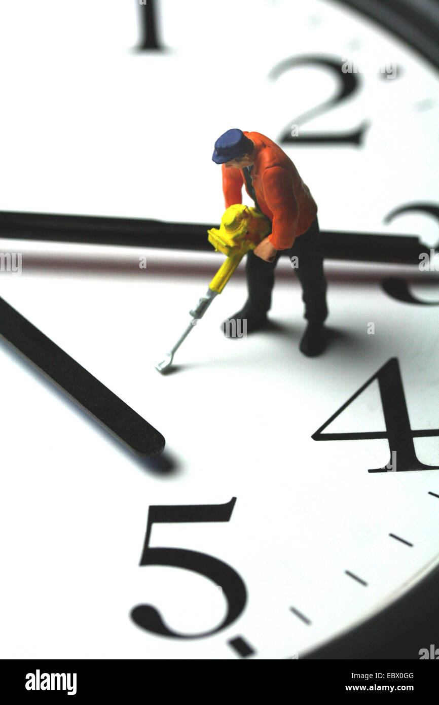 Bild "Arbeitszeit" Symbol: Modell Figur eines Arbeitnehmers mit einem Presslufthammer stehen auf einem Zifferblatt Stockfoto