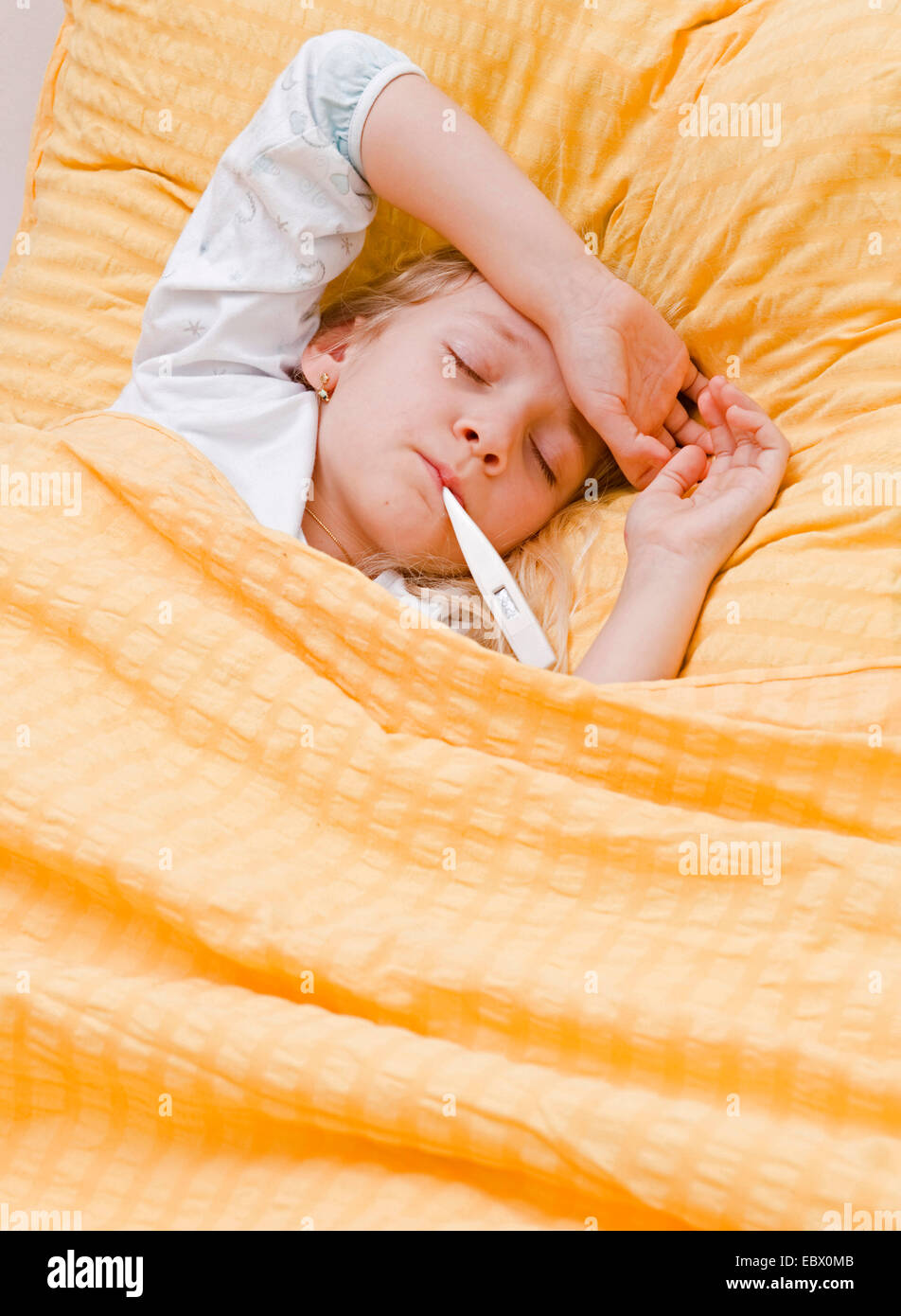 krankes Mädchen mit Fieberthermometer im Bett Stockfoto