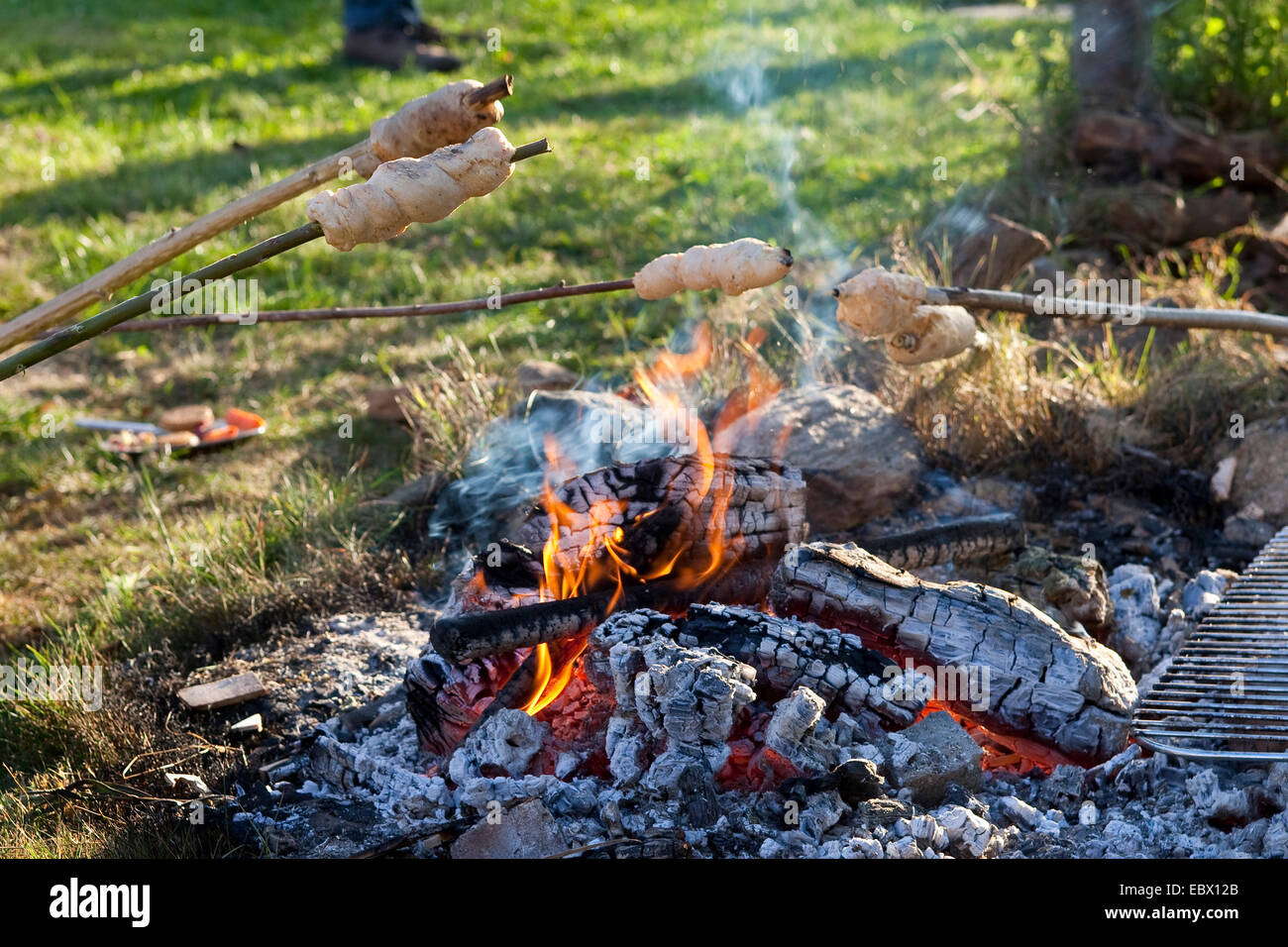 Kinder backen Brot über dem Lagerfeuer Stockfoto
