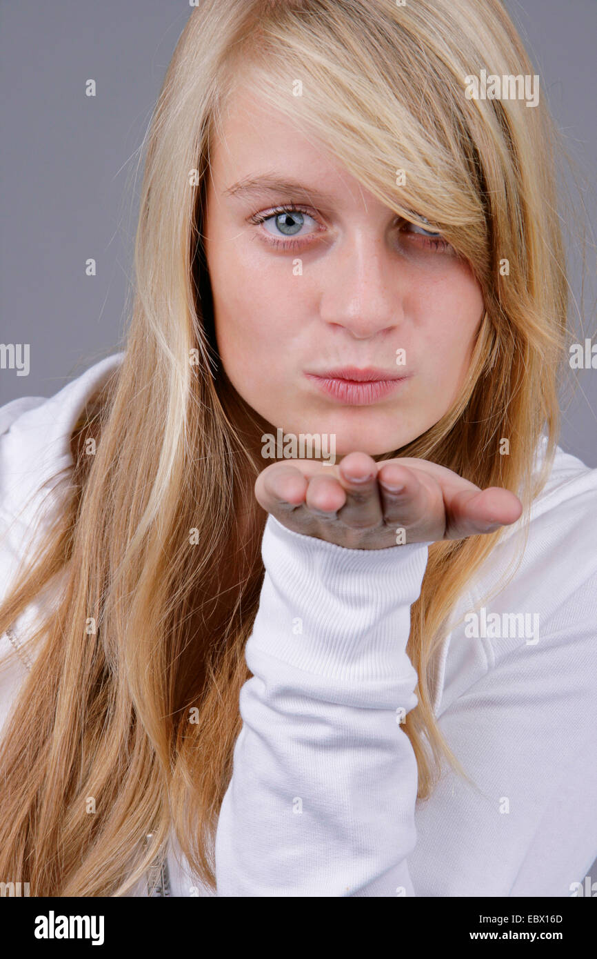 Junge, blonde Frau bläst einen Kuss, Deutschland Stockfoto