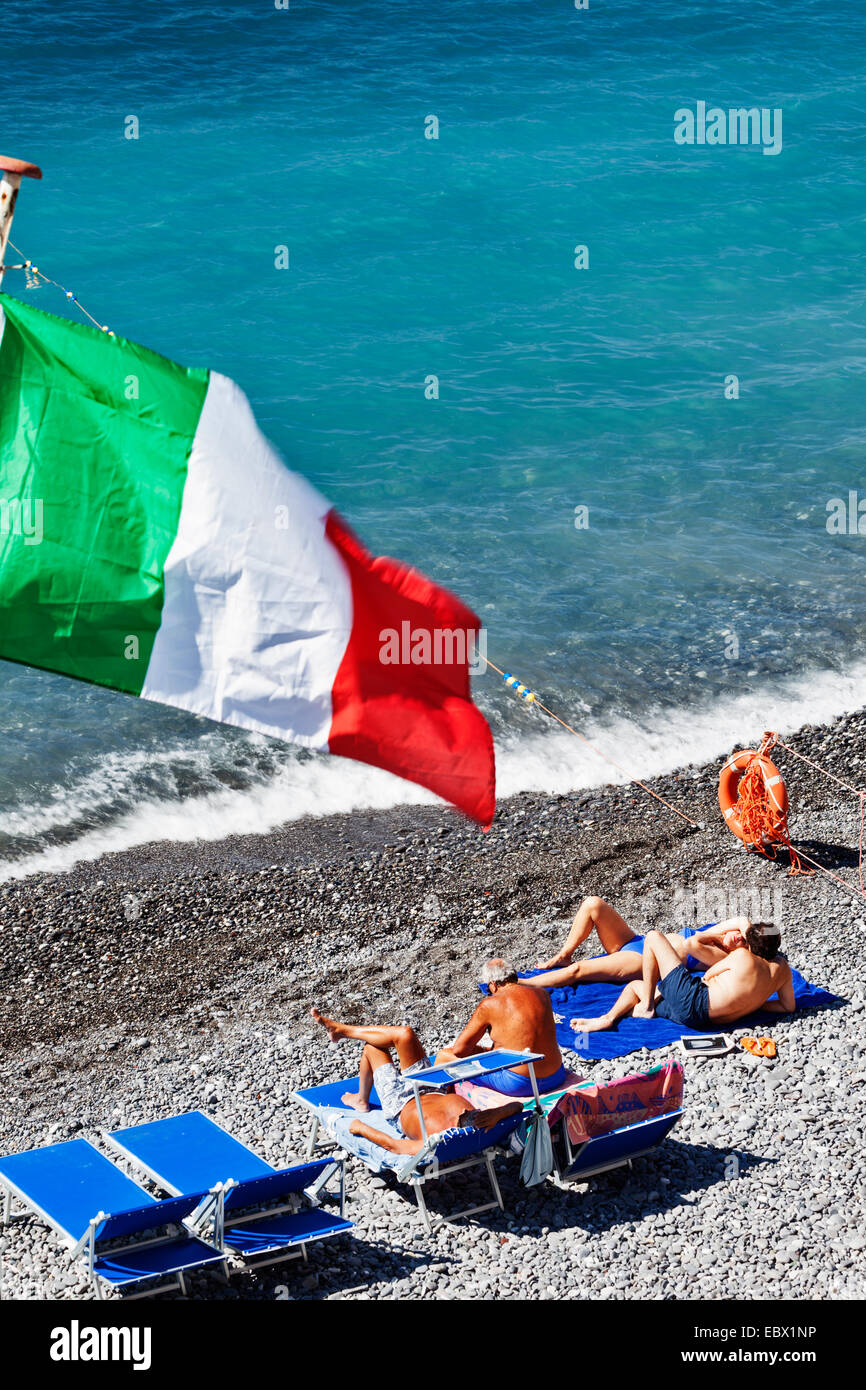 Touristen unter italienischer Flagge am Kiesstrand. Stockfoto