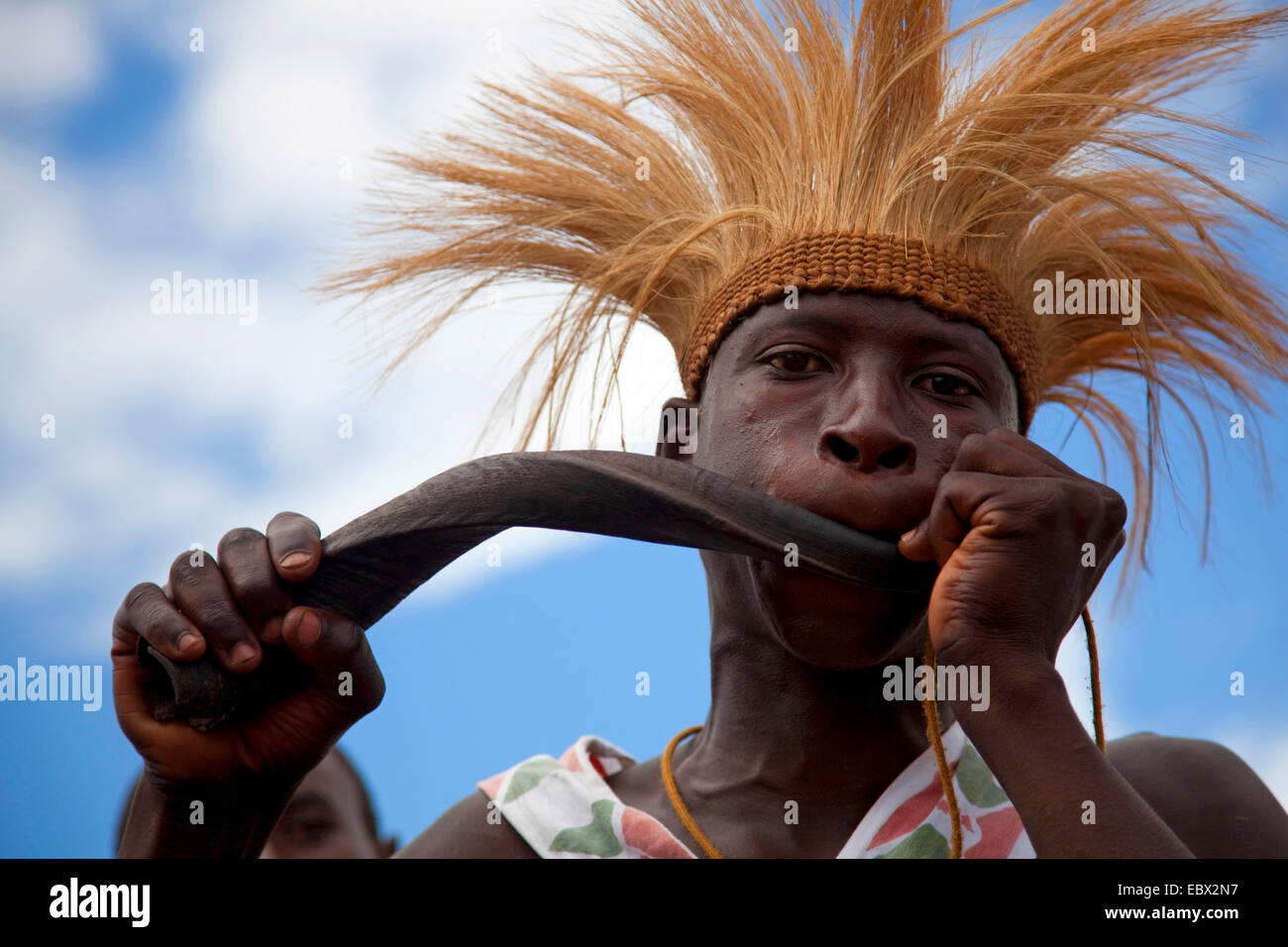 Tänzerin mit traditionellen Kopfschmuck weht ein Horn von Afrika, Burundi, Bujumbura Mairie, Bujumbura Stockfoto