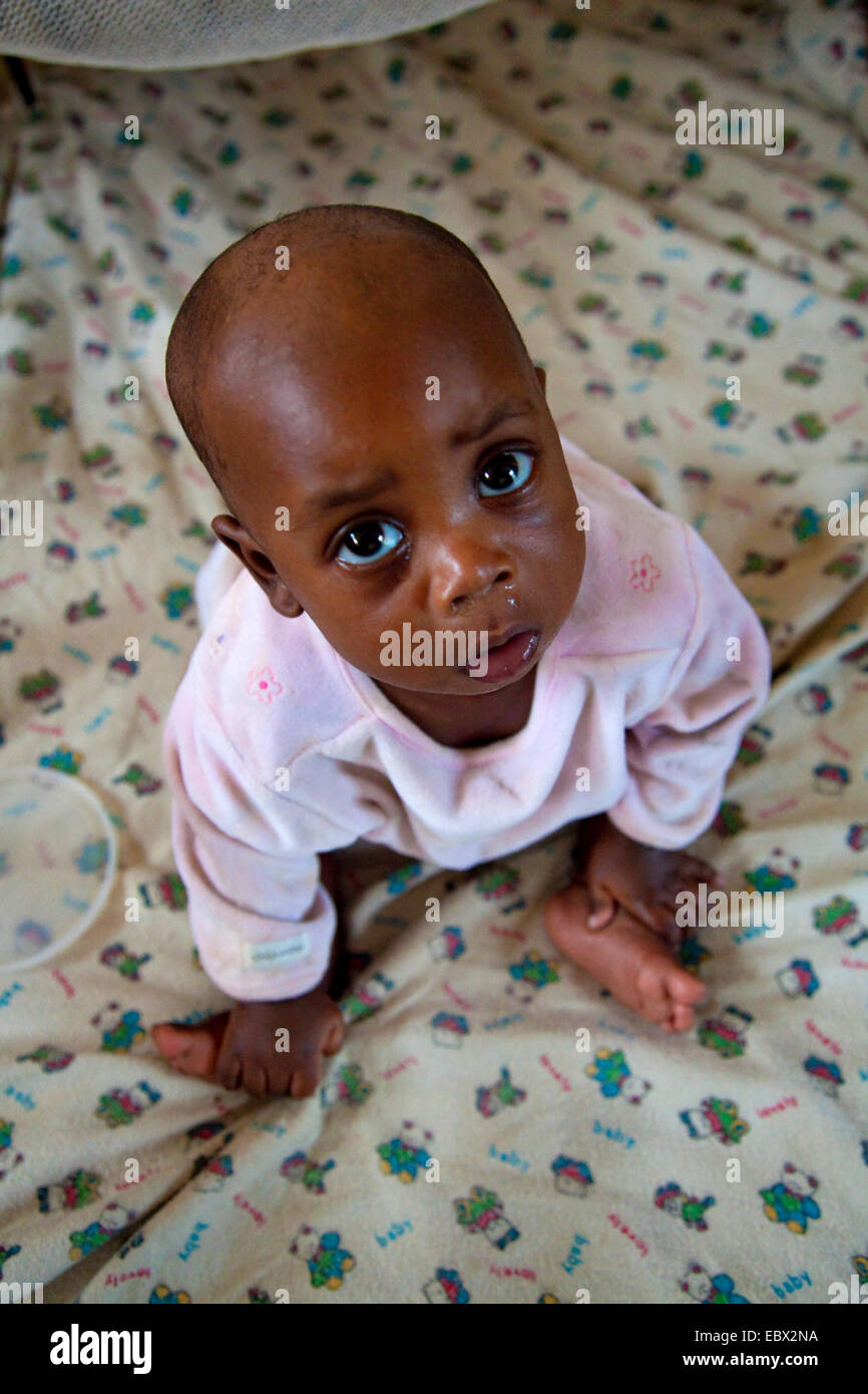 Kleinkind sitzt auf Bett, Porträt, Bujumbura, Burundi, Bujumbura Mairie Stockfoto