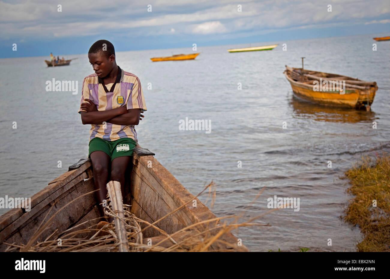 Junge sitzt auf Fischerboot am Tanganjikasee, Burundi, Makamba Stockfoto