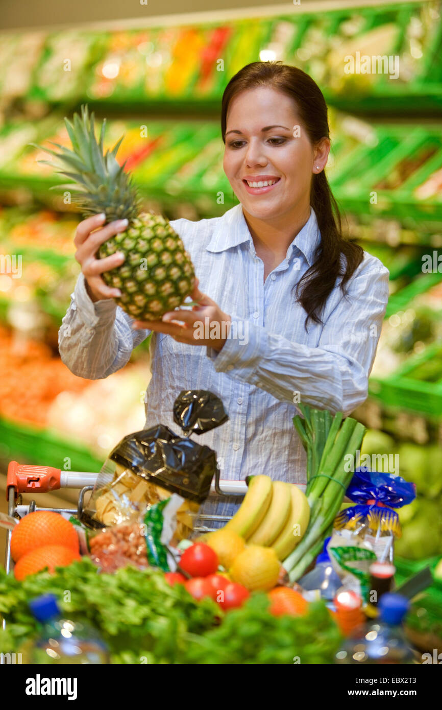 junge Frau im Supermarkt kauft Lebensmittel und Früchte Stockfoto