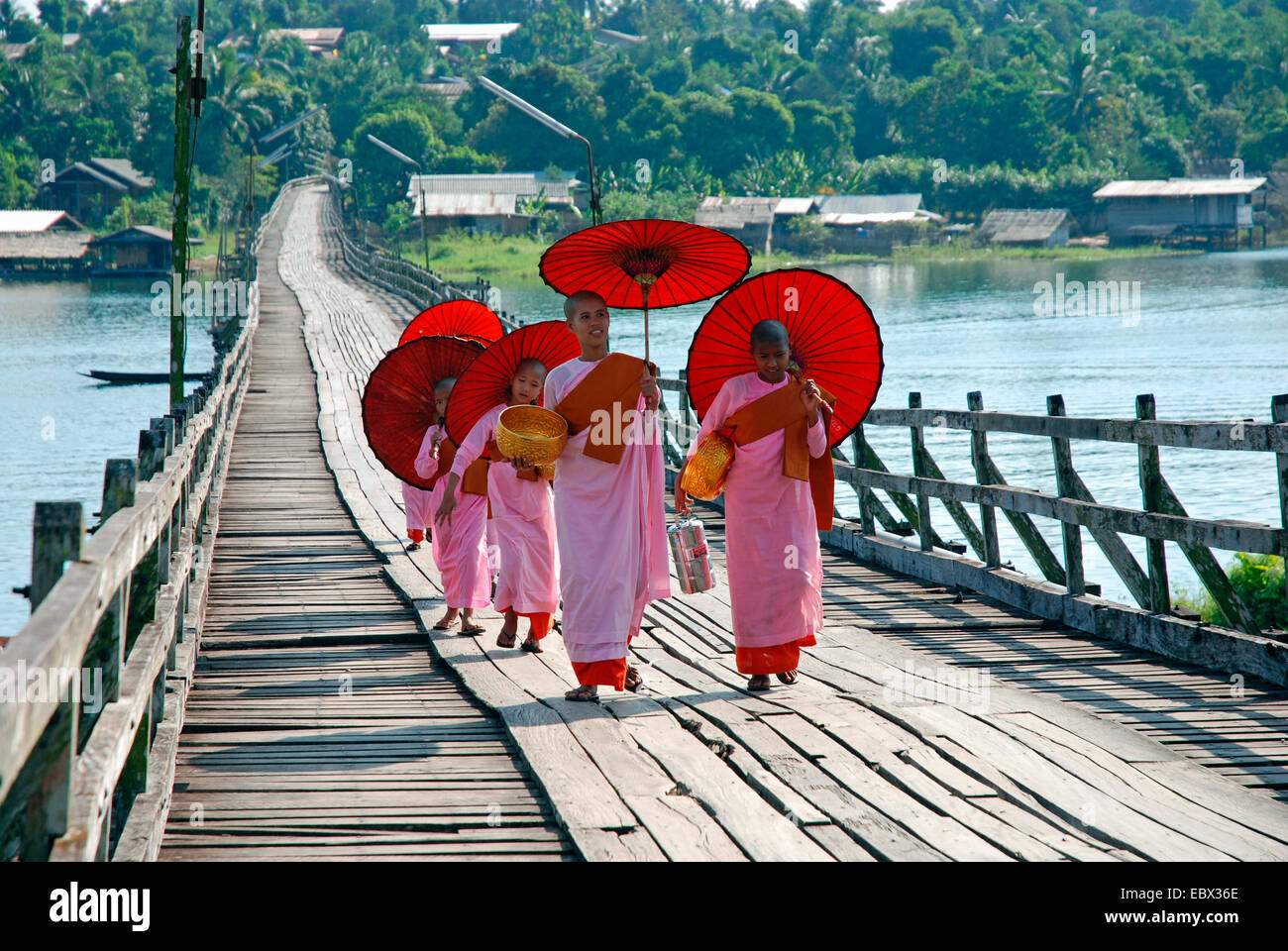 eine Gruppe von Nonnen und Kloster Schüler mit Sonnenschirmen auf einer Holzbrücke, Thailand, Sanglaburi Stockfoto