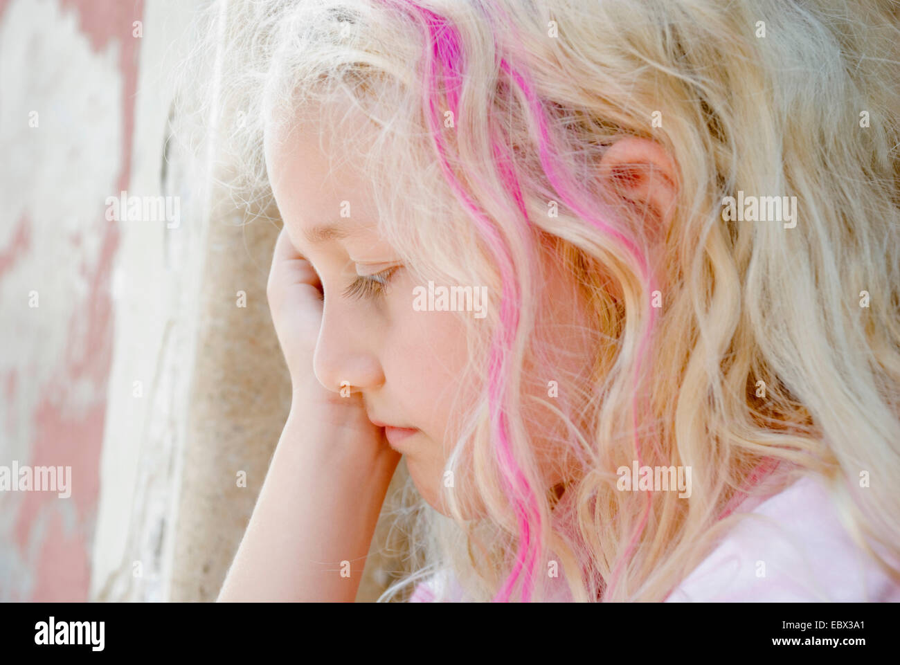 Trauriges Mädchen hockend an einer Wand Stockfoto