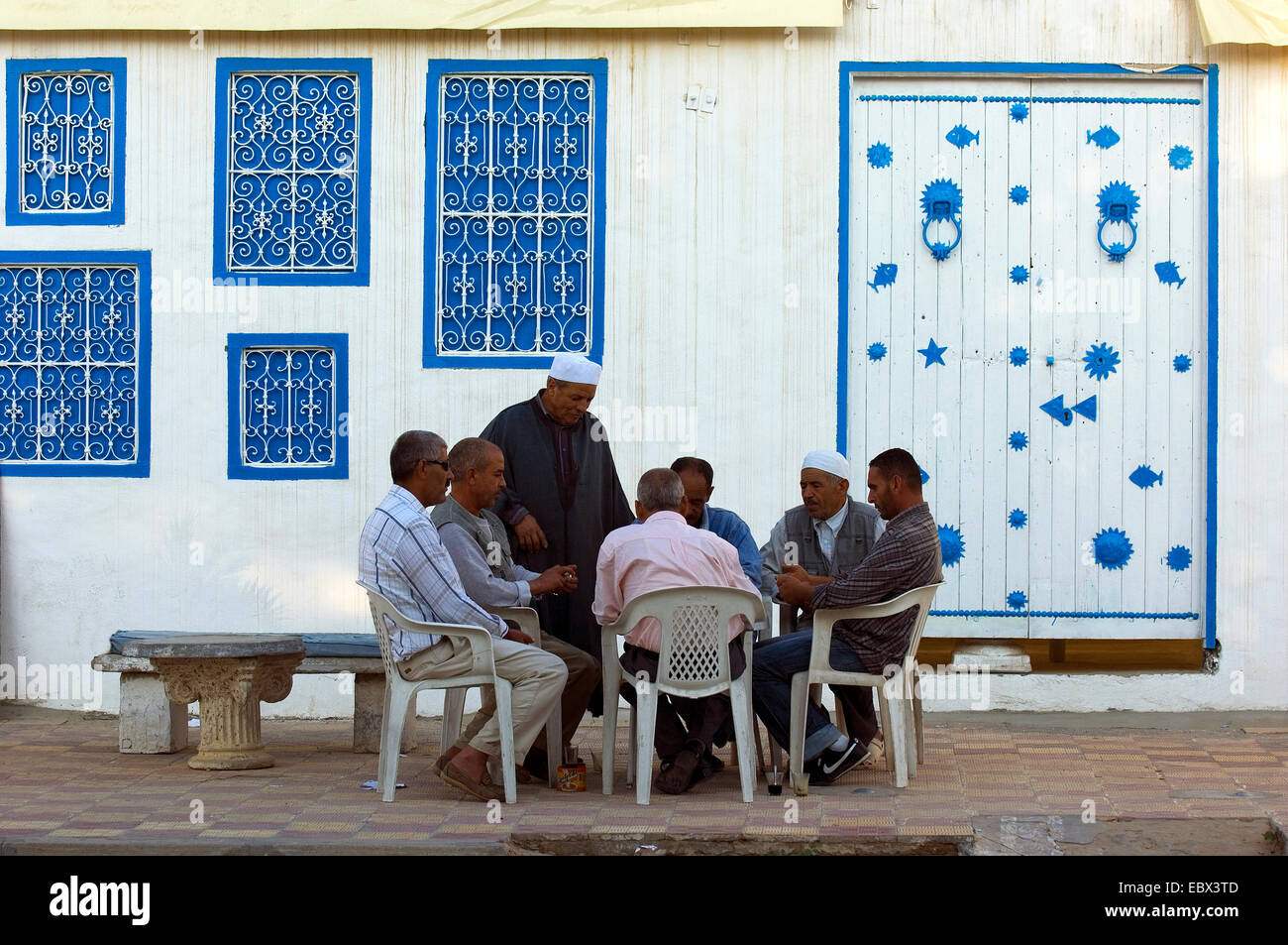 Männer sitzen an einem Tisch auf dem Bürgersteig spielen Domino, Tunesien, Djerba Stockfoto