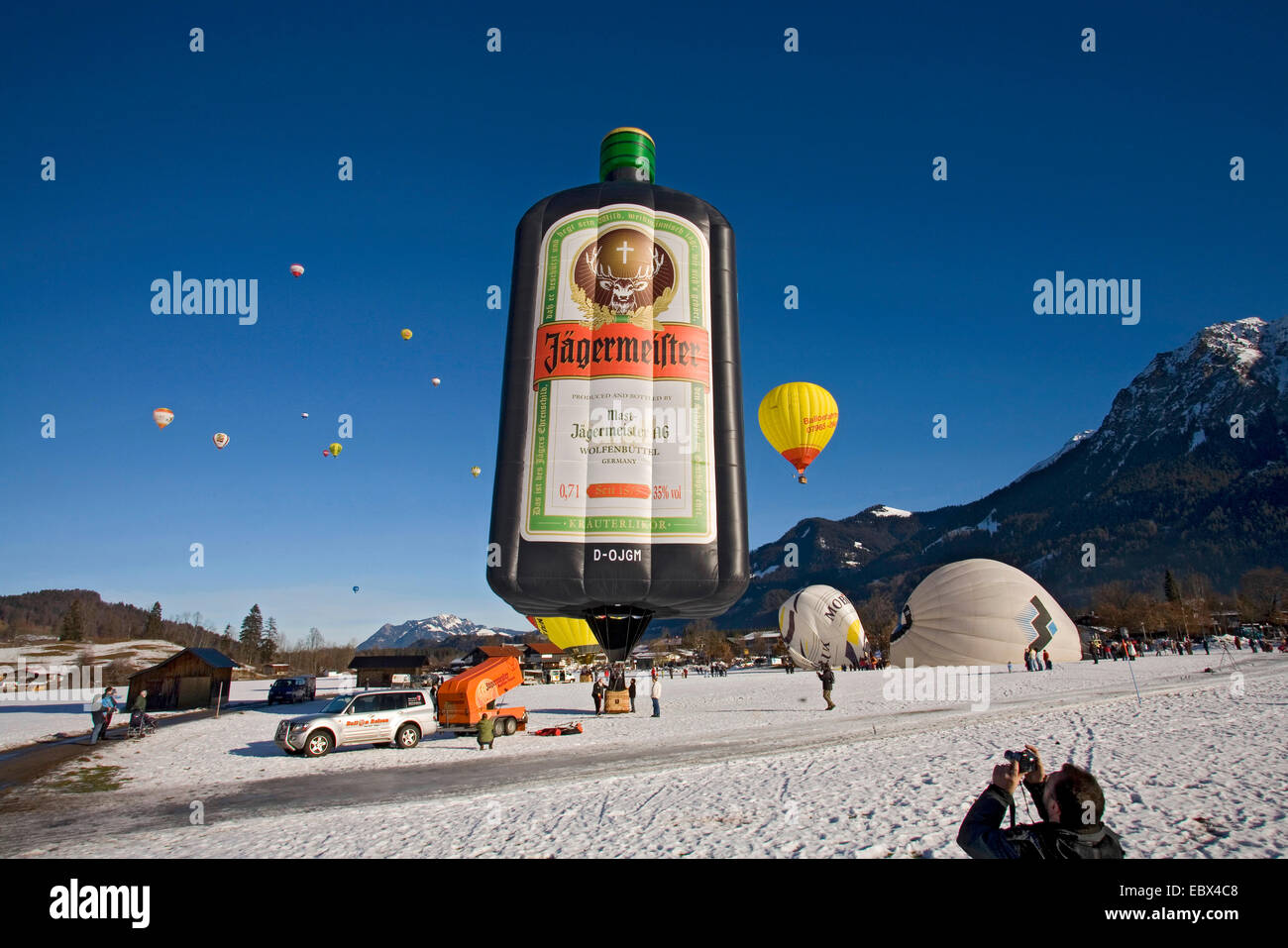 Heißluft-Ballon-Festival auf einem Schneefeld mit mehreren Ballons in Vorbereitung für den Start oder abgenommen haben und eine Menge von Zuschauern, Oberstdorf, Allgäu, Bayern, Deutschland Stockfoto