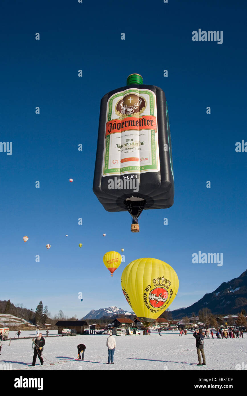 Heißluft-Ballon-Festival auf einem Schneefeld mit mehreren Ballons in Vorbereitung für den Start oder abgenommen haben und eine Menge von Zuschauern, Oberstdorf, Allgäu, Bayern, Deutschland Stockfoto