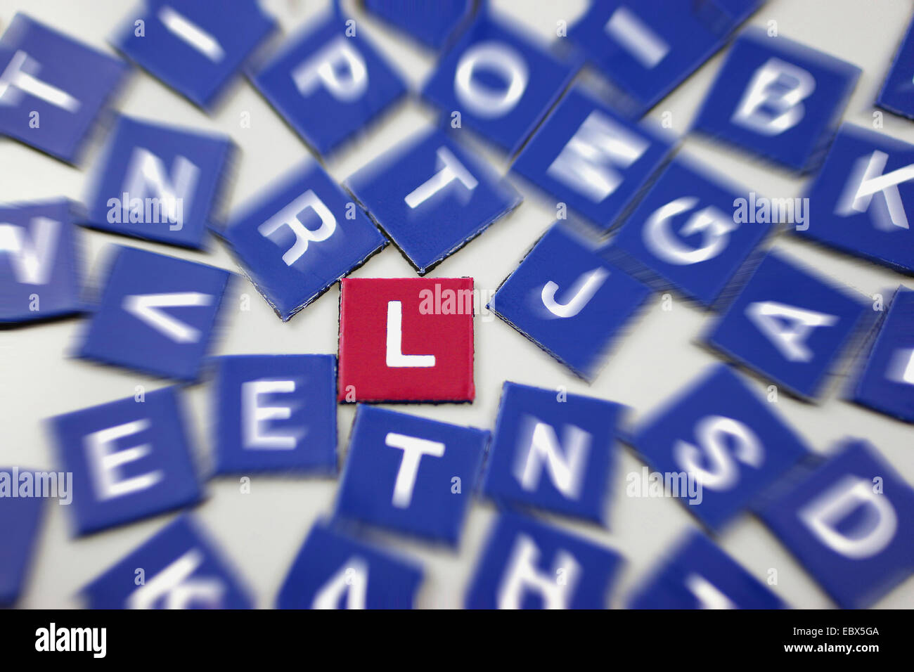 blaue Scrabble-Token mit Fokus auf einem rot L Stockfoto