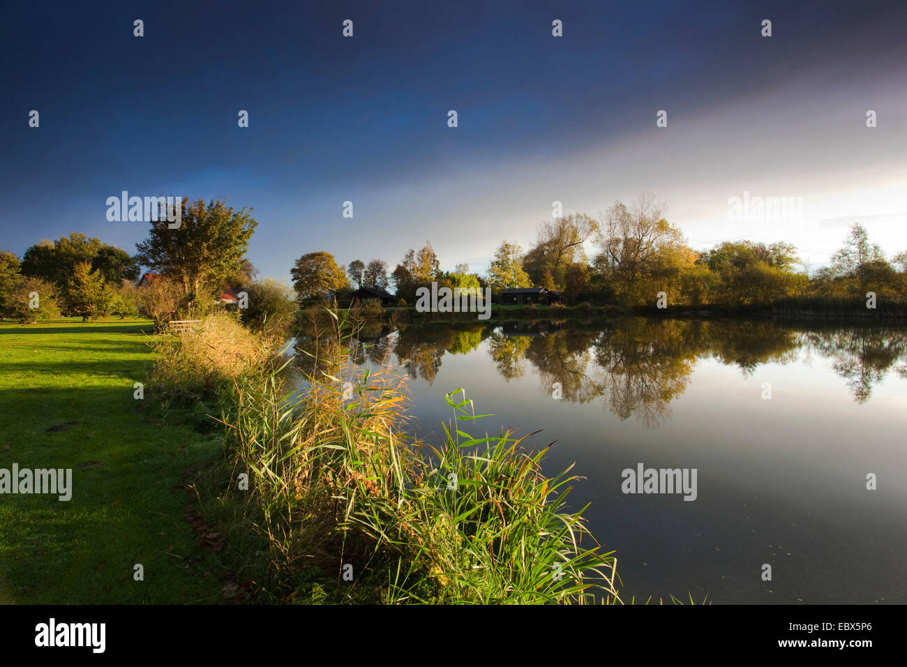 Sonne am Ufer eines Sees durch ein Loch in eine Wolkendecke, Deutschland, Niedersachsen, Vogtlaendische Schweiz, Dorum-Neufeld Stockfoto