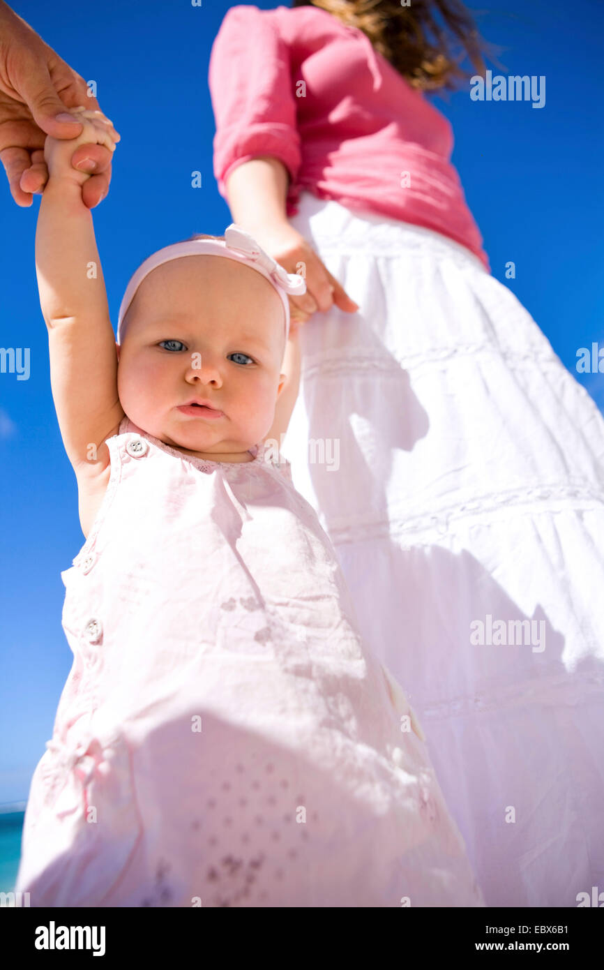 Junge Familie mit Baby Girl am weißen Sandstrand Stockfoto
