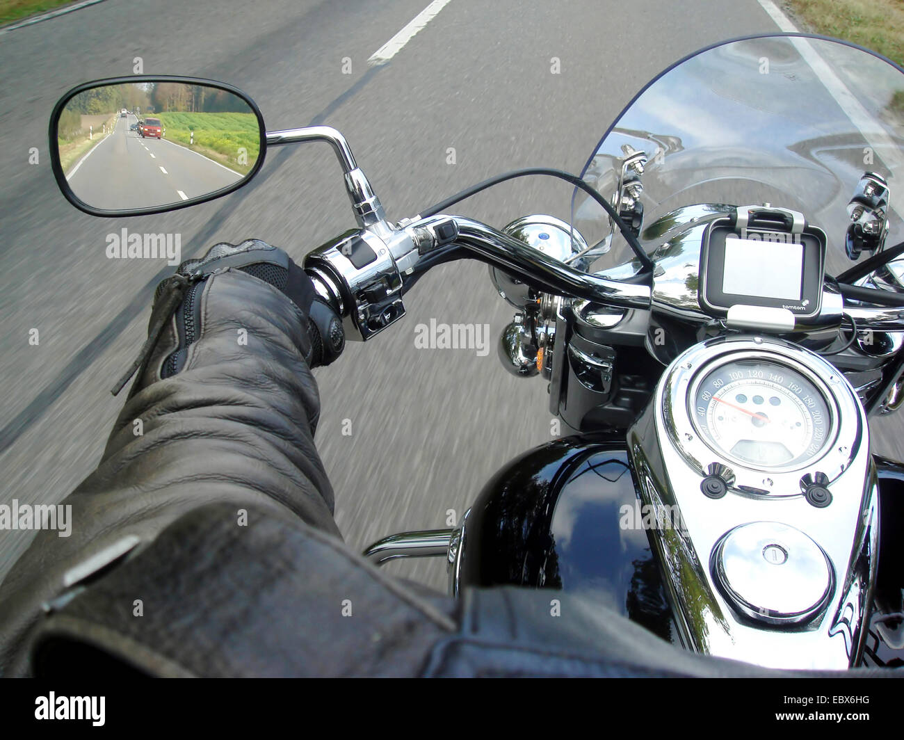 Biker auf einer Landstraße, Blick in den Rückspiegel Stockfoto