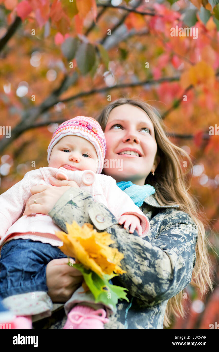 Junge Mutter mit Tochter genießen schöne Herbsttag Stockfoto