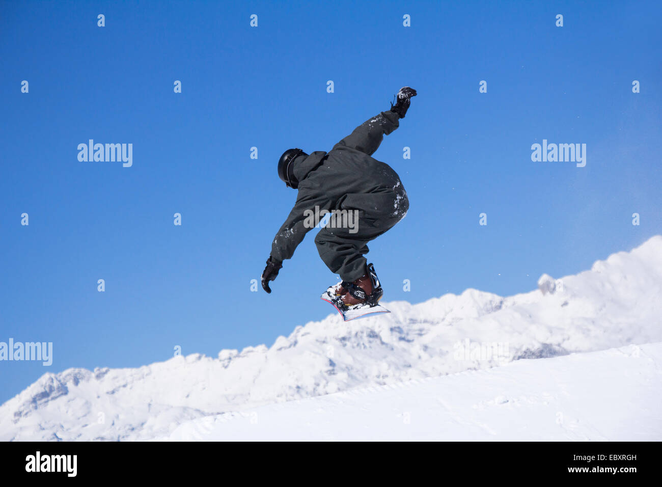 Snowboarder bei extremen Sprung im Hochgebirge am sonnigen Tag Stockfoto