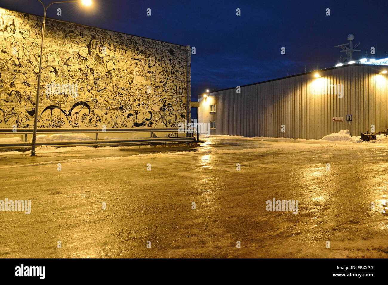 Bemalte Wand eines Lagers, beleuchtet von den Straße Lightning im Bereich Hafen, 24. Februar 2014 Stockfoto