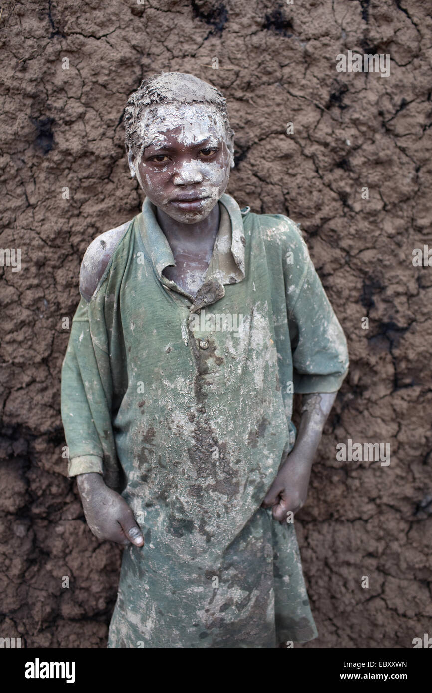 Porträt eines kleinen Jungen bilden Lehmziegeln, die in einem traditionellen Ofen verbrannt werden. Er hat zum Schutz vor der Sonne, Burundi, Kabezi, Kabezi Schlamm auf dem Kopf rieb. Stockfoto