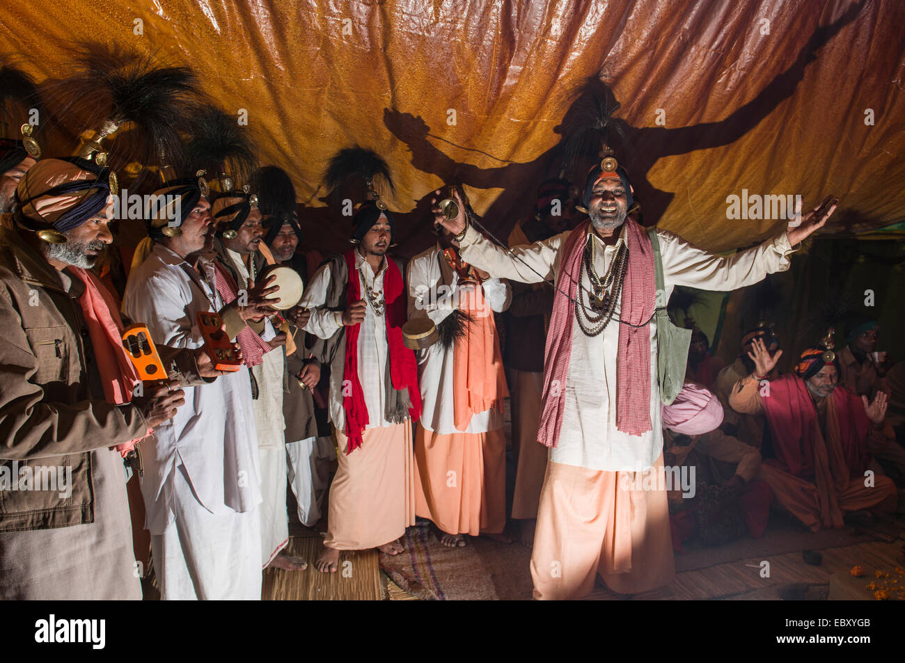 Gruppe von Jangam Sadhus, die heiligen Männer singen ein Lied für ein weiteres Sadhu in seinem Zelt bei der Sangam, dem Zusammenfluss der Flüsse Stockfoto