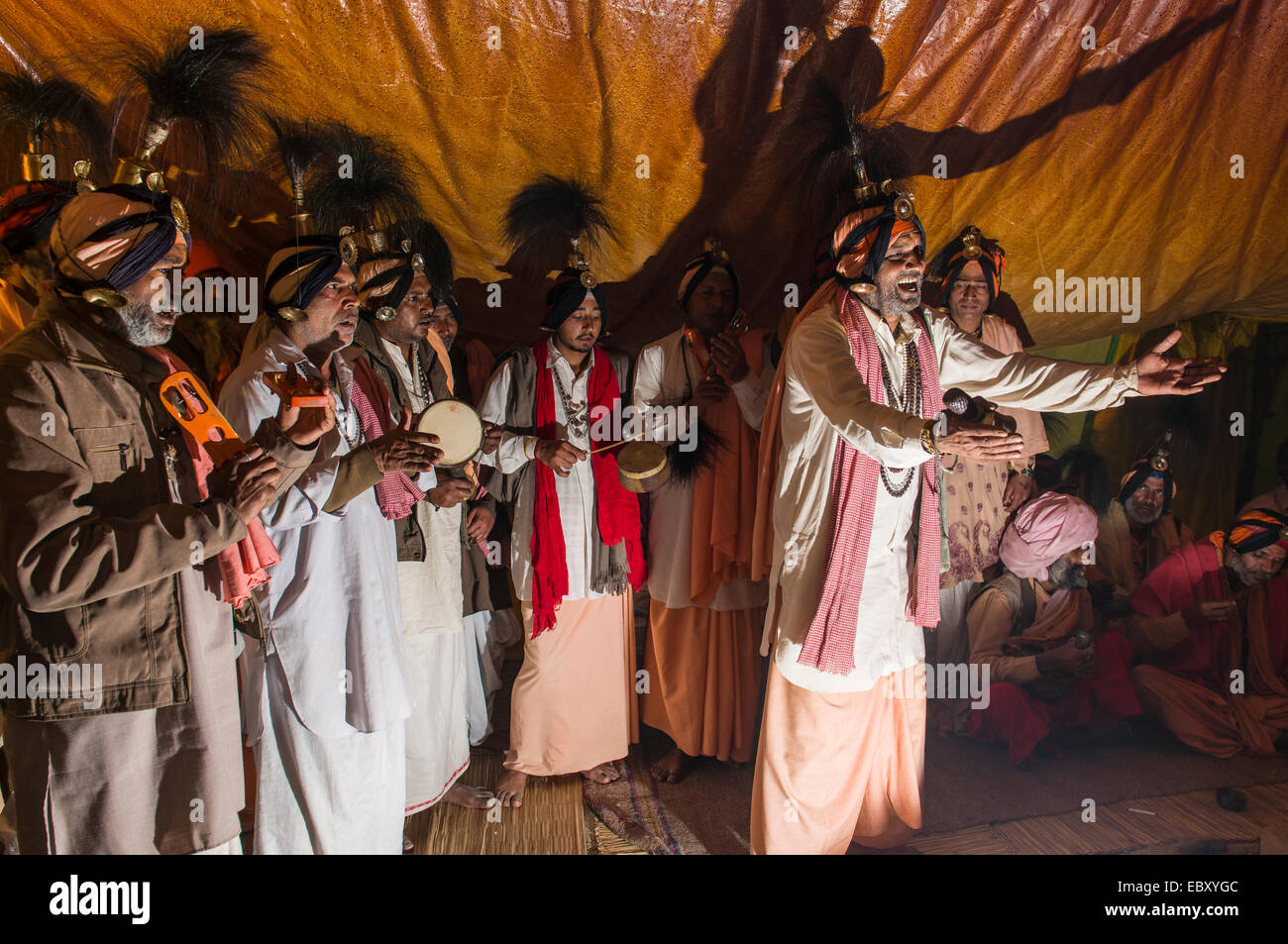 Gruppe von Jangam Sadhus, die heiligen Männer singen ein Lied für ein weiteres Sadhu in seinem Zelt bei der Sangam, dem Zusammenfluss der Flüsse Stockfoto