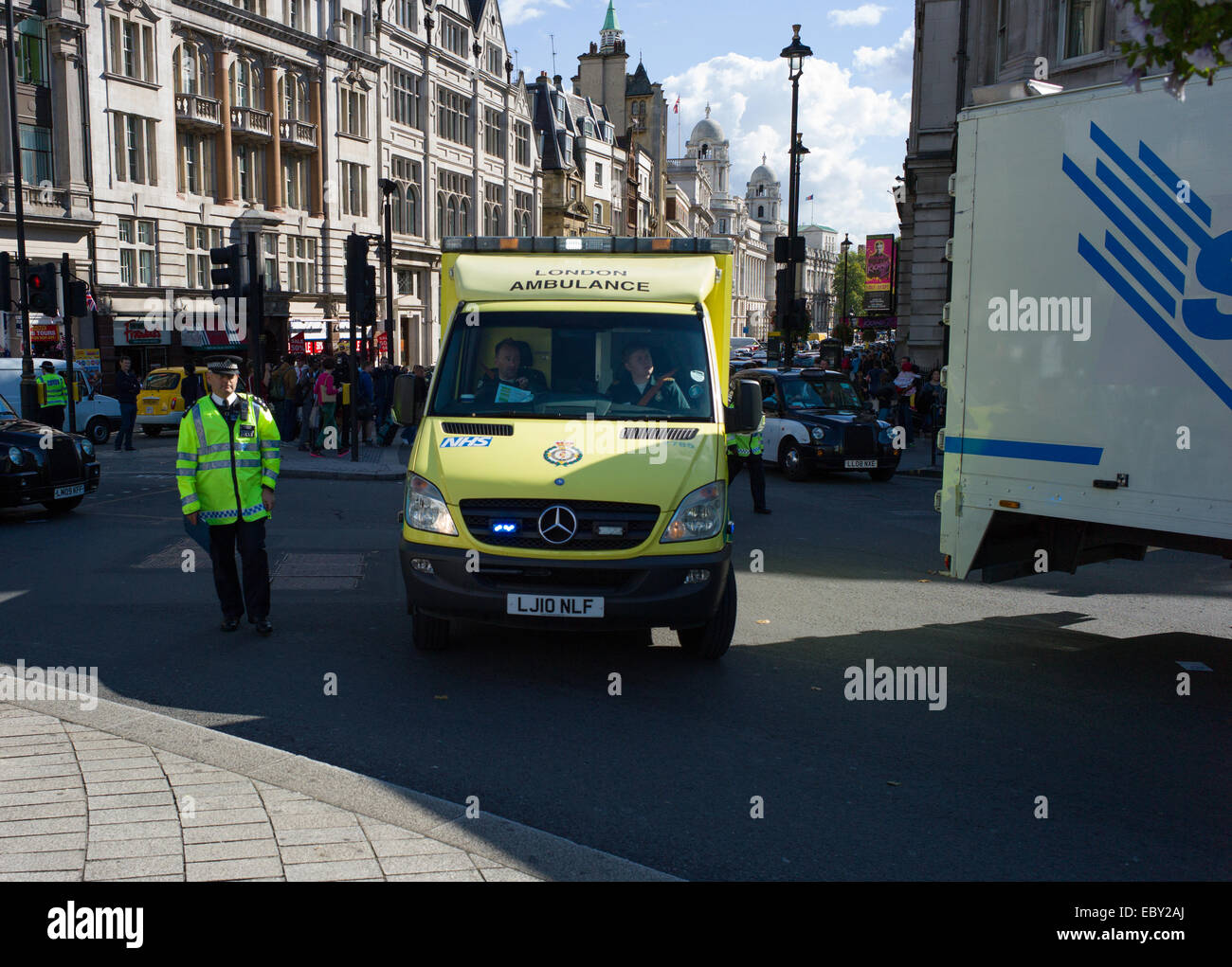 Ein londoner Krankenwagen ist durch den Verkehr von der Polizei in der Nähe von Trafalgar Square half Stockfoto